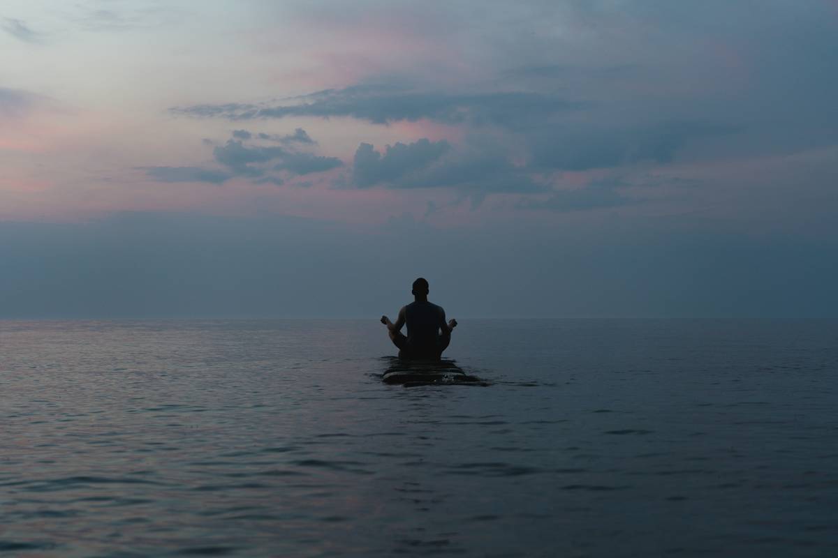 a man sitting on a surfboard in the middle of the ocean