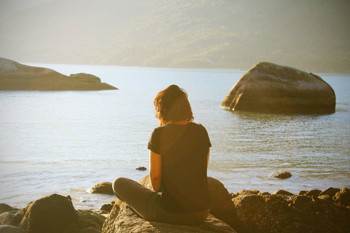Lua Valentia meditating on the beach.