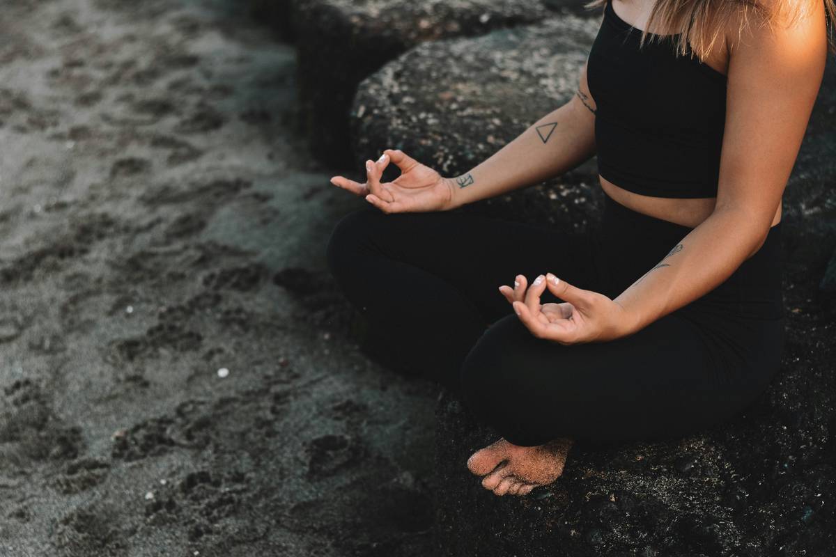 A woman meditating on the beach
