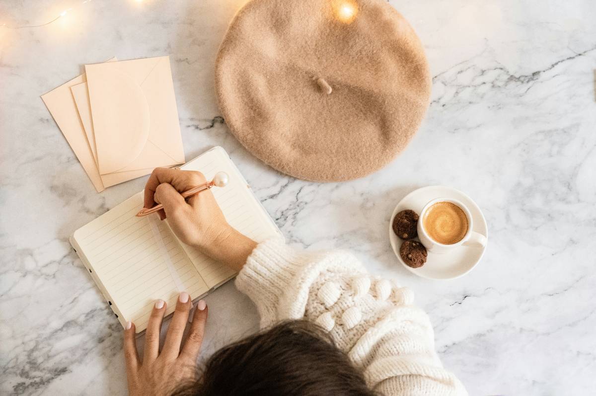 Woman practicing expressive writing for stress in a quiet room with journal and pen